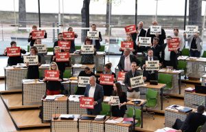 Die Abgeordneten der Linksfraktion im Sächsischen Landtag halten im Plenarsaal einzeln Schilder mit "Freistaat statt Polizeistaat" in die Höhe.